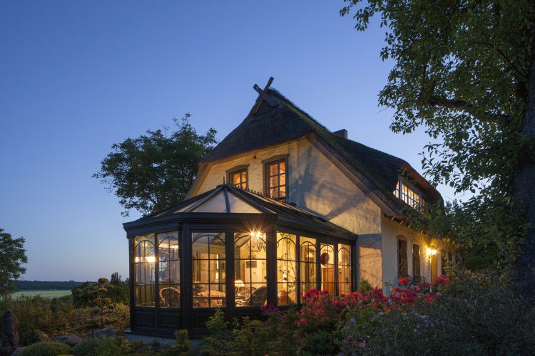 Photo de nuit d'une maison avec véranda